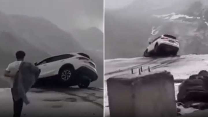 Terrifying moment car dangles precariously over sheer cliff drop sparking frantic mission to save occupants inside