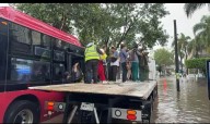 Policías viales rescatan con una grúa a 43 pasajeros de un camión varado por la inundación