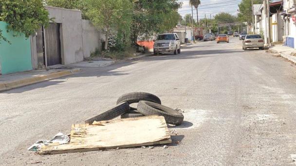 Con llantas y madera alertan de tapas en las alcantarillas