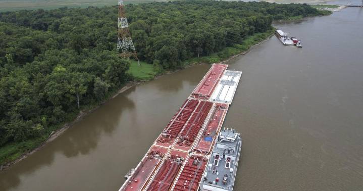 Two die when helicopter strikes powerlines and crashes into a barge on the Mississippi River