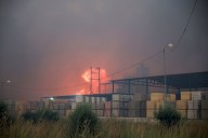 Wildfires fanned by heatwave and strong winds rage across Europe, burning houses and factories