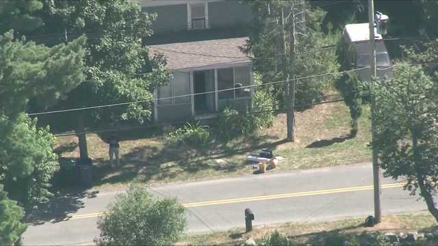 Road closed, investigators seen working at Mass. home