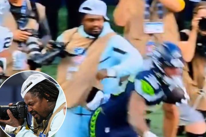 Marshawn Lynch stiff arms player to protect his camera during Seahawks preseason game