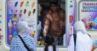 Famous ice cream seller stabbed to death 'eight times' in front of van as two people arrested