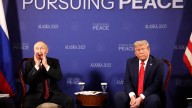Moment Trump and Putin's photocall erupts into CHAOS as smirking Vlad tries to shout over journalists before peace talks