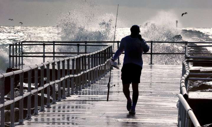 Hurricane Erin pacts strong winds and floods part of a NC highway as it slowly moves out to sea