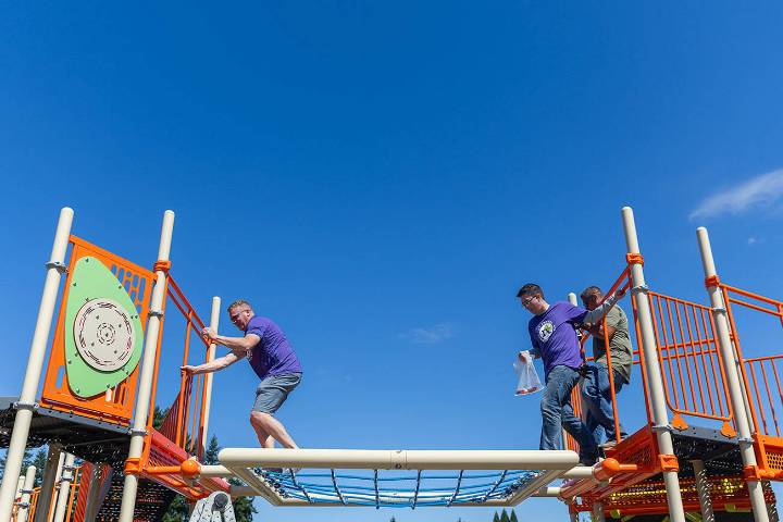 Volunteers and staff build a playground for new Marysville school