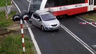 Shocking moment driver smashes through barrier & stops on level crossing before being wiped out by train