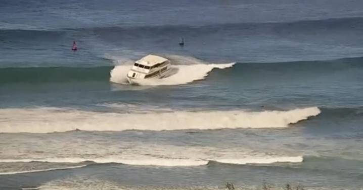 Barco de pasajeros tipo yate encalla en fuerte oleaje frente a playa de Hawai