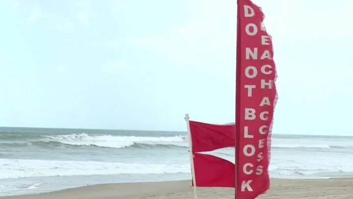 Hurricane Erin stirs up strong winds and floods part of a NC highway as it slowly moves out to sea