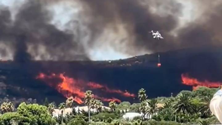 Espectacular maniobra del Infoca: un helicóptero toma agua en la playa de Los Alemanes para combatir el incendio de Tarifa