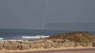 Horrifying moment plane corkscrews and nosedives into the sea at high speed during airshow as pilot feared dead