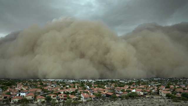 A towering wall of dust has rolled through metro Phoenix with storms that left tens of thousands of people without power and delayed flights at the city airport