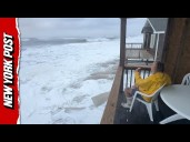 Woman Calmly Sitting On Porch While Hurricane Erin Pounds Outer Banks Shoreline