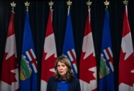 Premier Danielle Smith defends new COVID shot administration fee during radio show