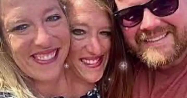 Conjoined twins Abby and Brittany Hensel seen carrying newborn baby
