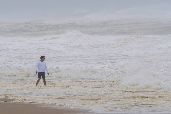 Hurricane Erin stirs up strong winds and floods part of a NC highway as it slowly moves out to sea