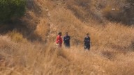Padre del bebé Emmanuel visto con agentes en campo remoto de Moreno Valley durante búsqueda del cuerpo del niño