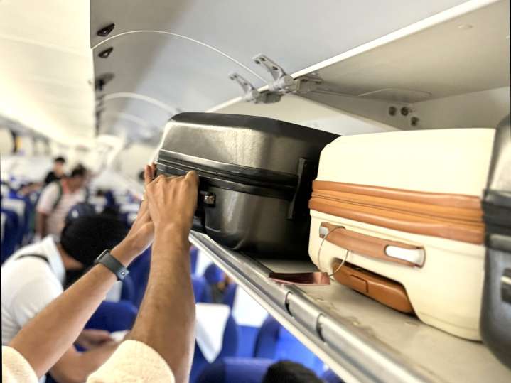 The Secret Way to Always Get Overhead Bin Space on a Flight, According to Travel Pros