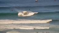 Yacht-sized passenger boat runs aground in high surf off Hawaii beach