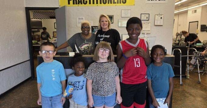 Students receive haircuts and books courtesy of Academy of Hair Design & Pillars of the Community