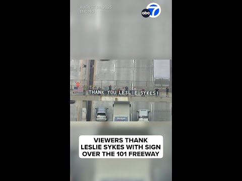 Viewers thank Leslie Sykes with sign over 101 Freeway