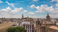 Un operario deja un ataúd usado en un contenedor de basura en Castilblanco (Sevilla)