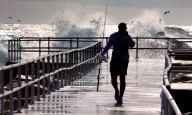 Hurricane Erin stirs up strong winds and floods part of a NC highway as it slowly moves out to sea