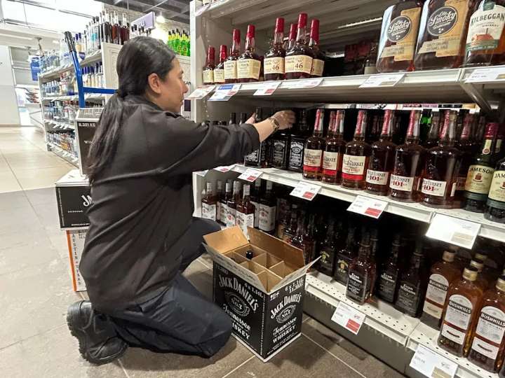 A Nova Scotia Liquor Corporation employee is shown removing bottles of Jack Daniel's whisky from a store shelf earlier this year after the NSLC pulled American alcohol from its shelves as part of Cana