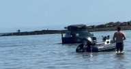 Car stranded in the sea on busy Bank Holiday at Oxwich Bay in Wales
