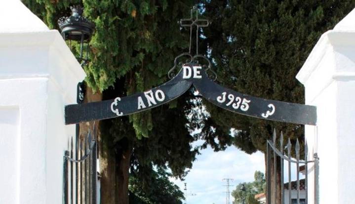 Un operario deja un féretro en un contenedor de basura cerca del cementerio de Castilblanco
