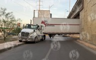 La fallan cálculos a trailero y se atora debajo de puente