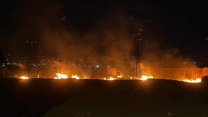 Bomberos trabajan en la extinción de un incendio cercano a una estación eléctrica de Las Gabias