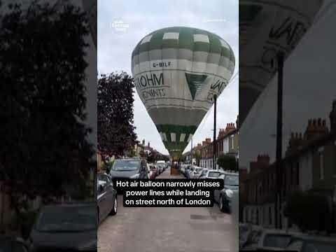 Hot air balloon narrowly misses power lines while landing on street north of London #shorts