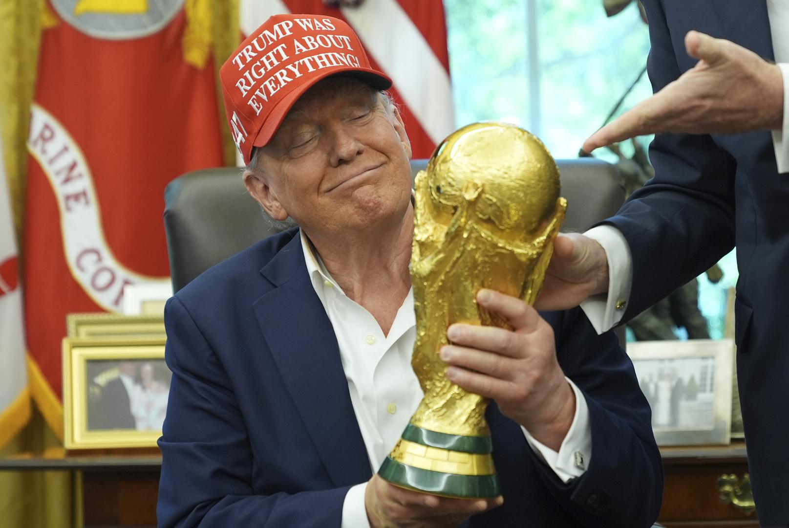 Trump holds World Cup trophy and is given finals ticket as he announces 2026 draw to be held in DC