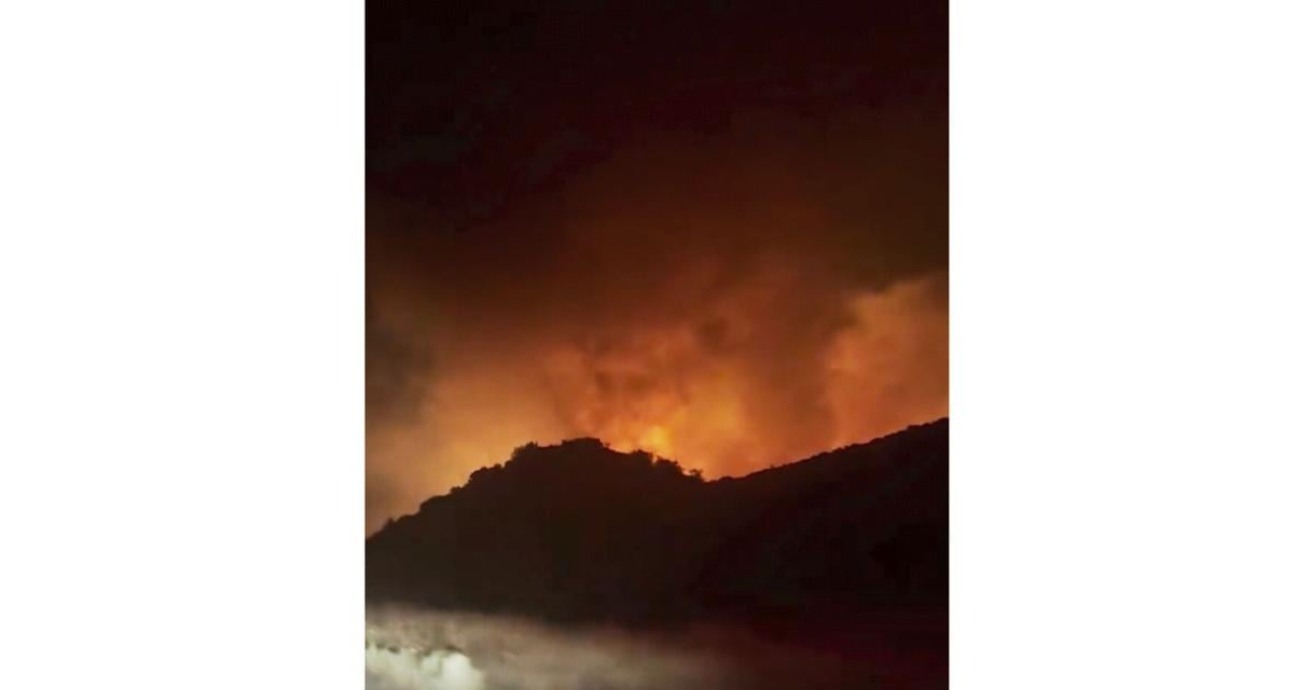 Firefighters battle a fast-moving blaze along a highway north of Los Angeles