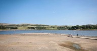 Dramatic images show reservoir 'beach' as warning issued over falling water levels
