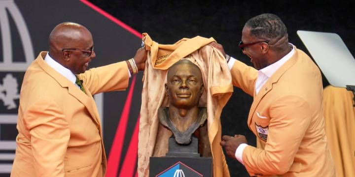 Sterling Sharpe gives fellow Pro Football Hall of Fame brother Shannon his gold jacket