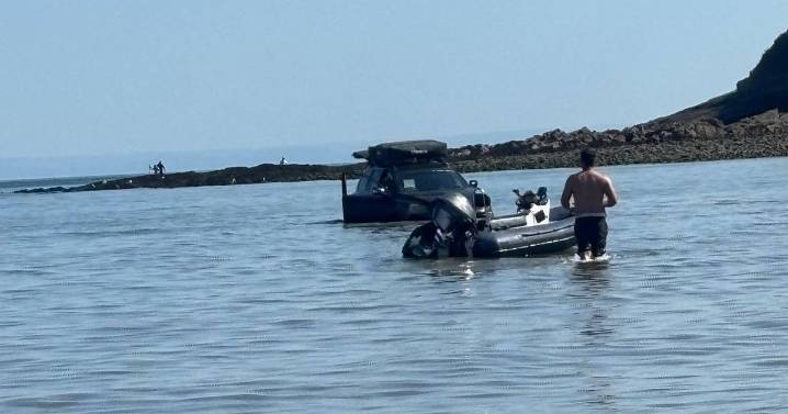 Baffled beachgoers say 'how did it get there' as car is seen submerged in water