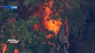 Flames erupt behind a home in Southwest   Miami