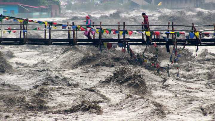 Building collapses into overflowing river during India floods
