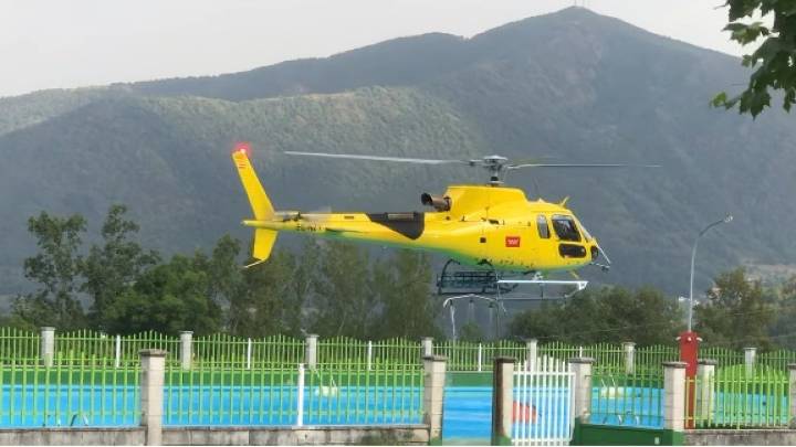 Un helicóptero carga agua en las piscinas del Carbachón para sofocar el incendio de Orallo