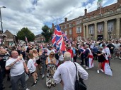 Anti-immigration protestors draped in English flags gather outside Town Hall in Nuneaton