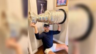 Bennett poses with Stanley Cup in front of childhood poster of trophy