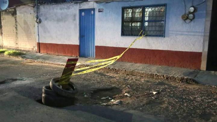 Vecinos tapan con llantas nuevo hundimiento asfáltico en Coatepec