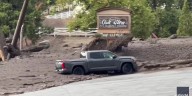 Watch: Woman trapped trying to save truck as wall of muddy water slams into California town