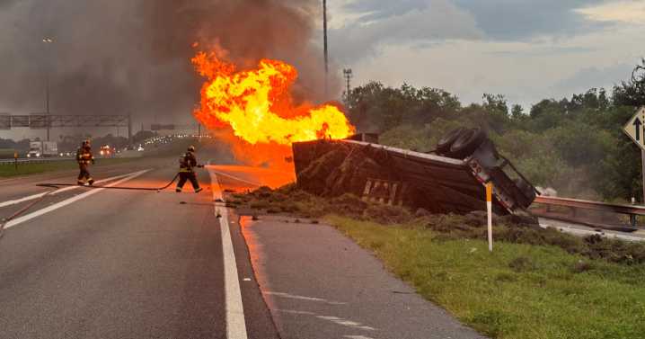 Driver hospitalized with serious injuries after tractor-trailer overturns, catches fires on I
