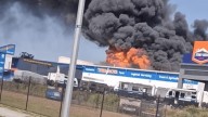 Man in life-threatening condition, cars incinerated after enormous inferno rips through popular tyre shop in Moreton Bay