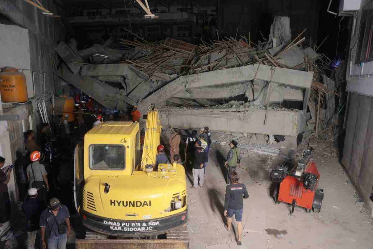 Rescuers run oxygen to survivors in Indonesia school building col...