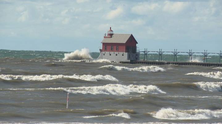 Surfers and campers ride out high waves and drifting sands in Grand Haven